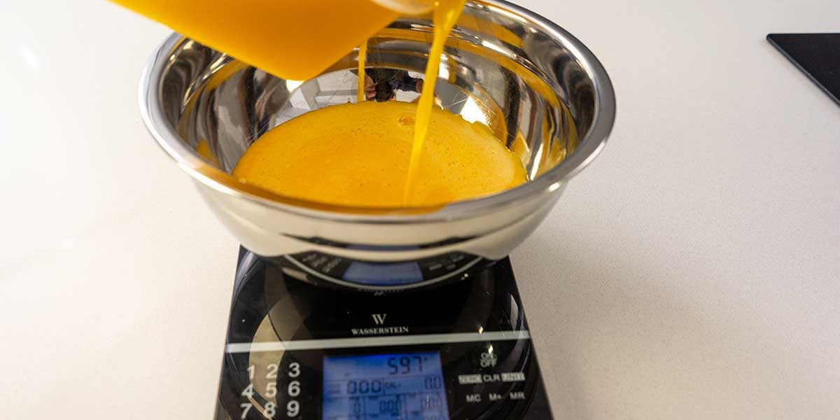 Weighing scrambled liquid eggs on a black food scale