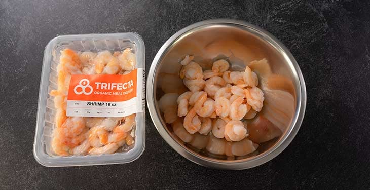 Trifecta meal delivery shrimp and cooked shrimp on a stainless steel bowl