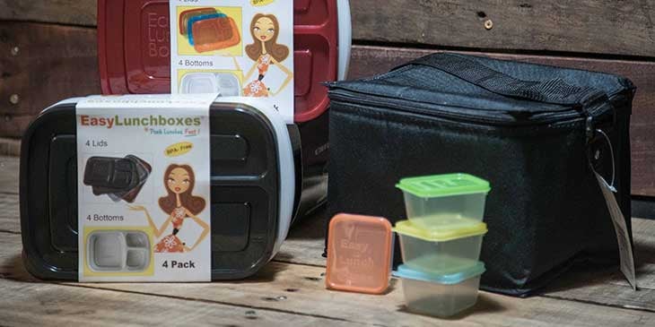 Various sized  plastic meal prep containers next to a black lunch box on a wooden background