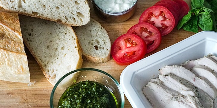 ingredients for pesto chicken sandwich recipe on cutting board