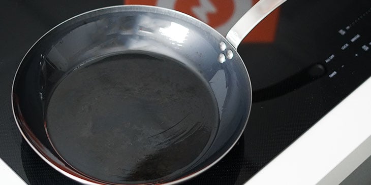 madein wok carbon steel pan placed on a electric stove top