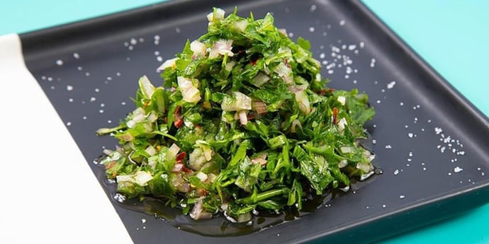 Chimichurri sauce on a white and black rectangular plate