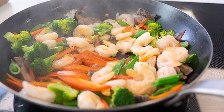 cooking shrimp stir fry in wok 