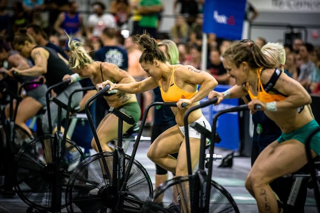 Female CrossFit athletes competing on the assault bike