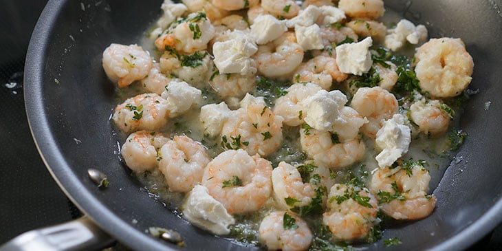 Goat cheese added to garlic, herb, and shrimp mix in a non-stick saute pan