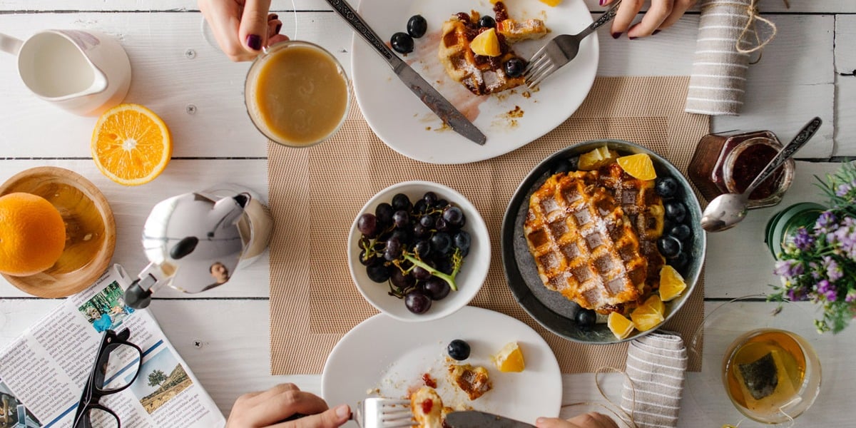 Brunch staple items on a table served in different sized white plates