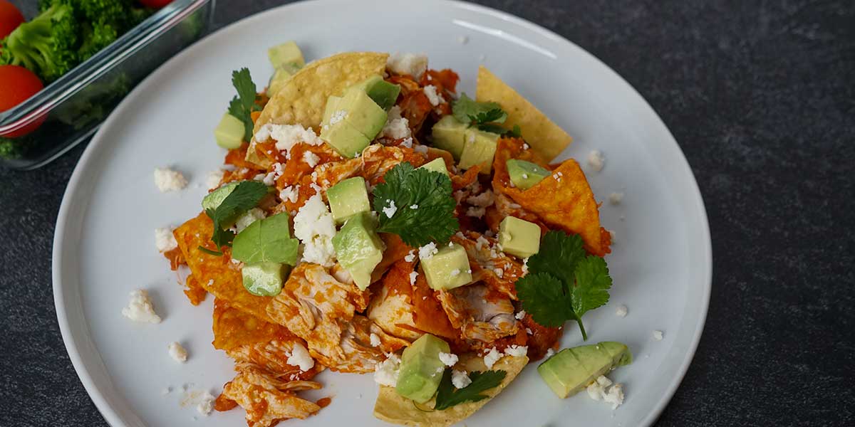 Chilaquiles Chicken Recipe plated on a beautiful white porcelain plate on a black mate background