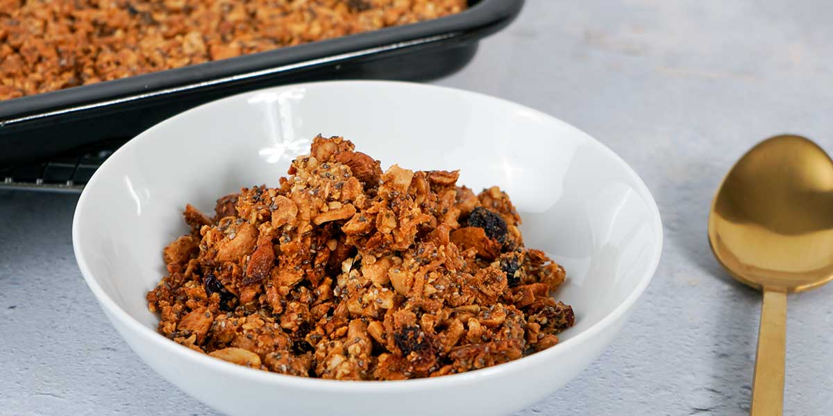 Paleo Gluten Free Granola Recipe served on a white bowl with a black tray in the background