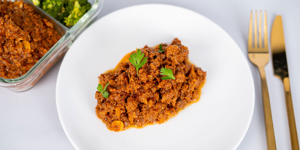 Paleo-beef-sloppy-joe-on-a-white-plate-with-parsley-garnish
