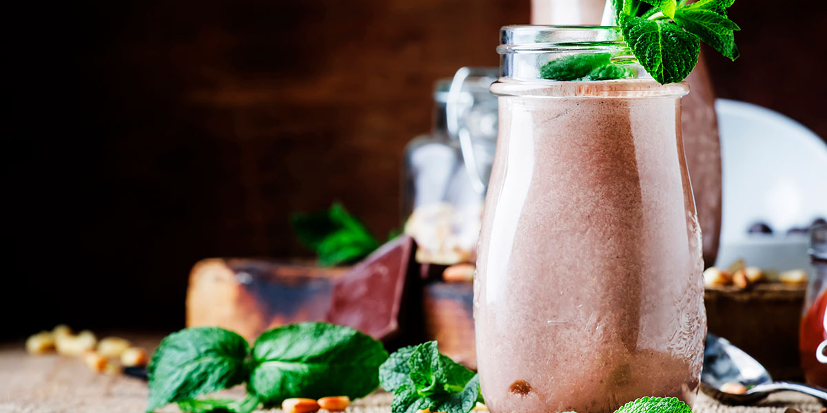 Peanut Butter-Chocolate Keto Breakfast Shake Recipe with basi mint in a wooden background