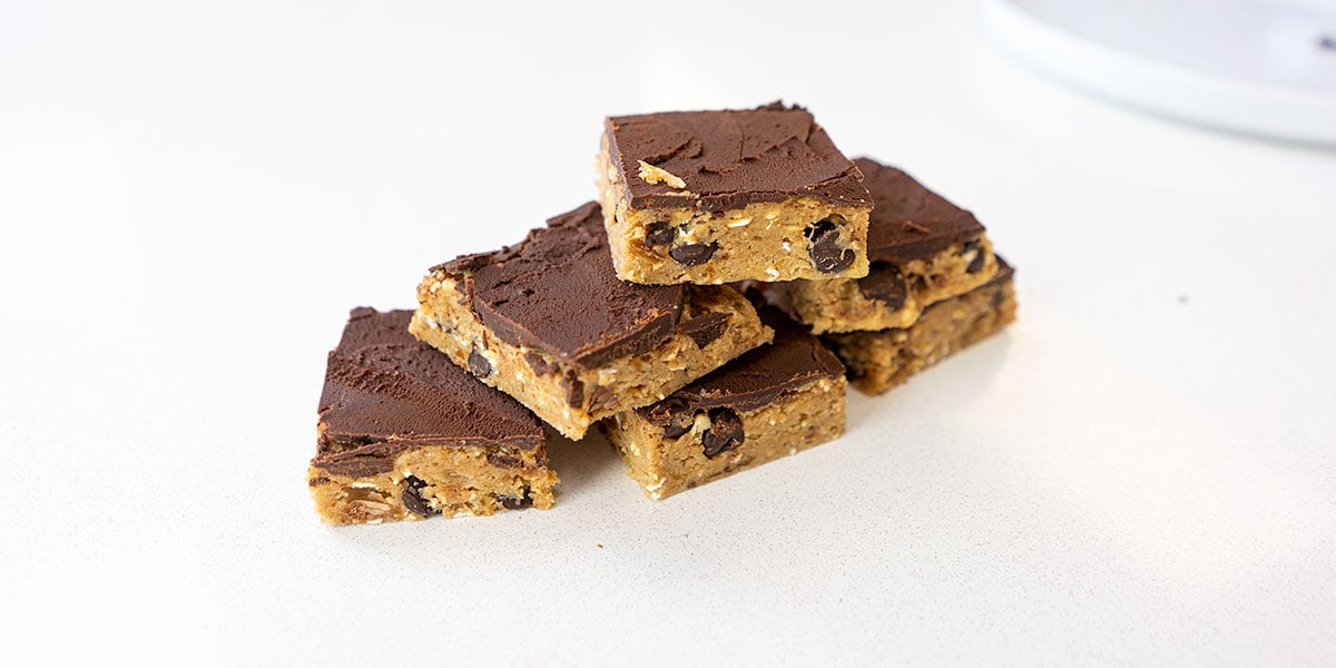 cookie dough protein bar recipe portioned into squares on a white background