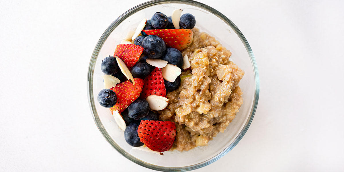 quinoa breakfast bowl recipe plated on a clear round meal prep container