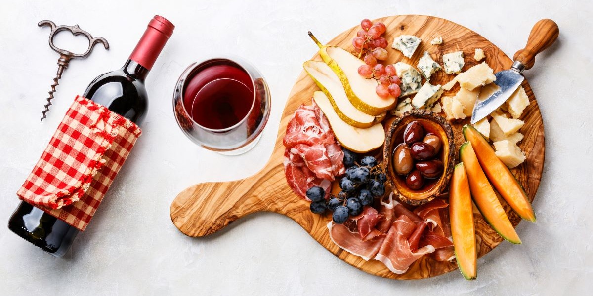 red-wine-glass-with-meat-cheese-and-fruit-platter